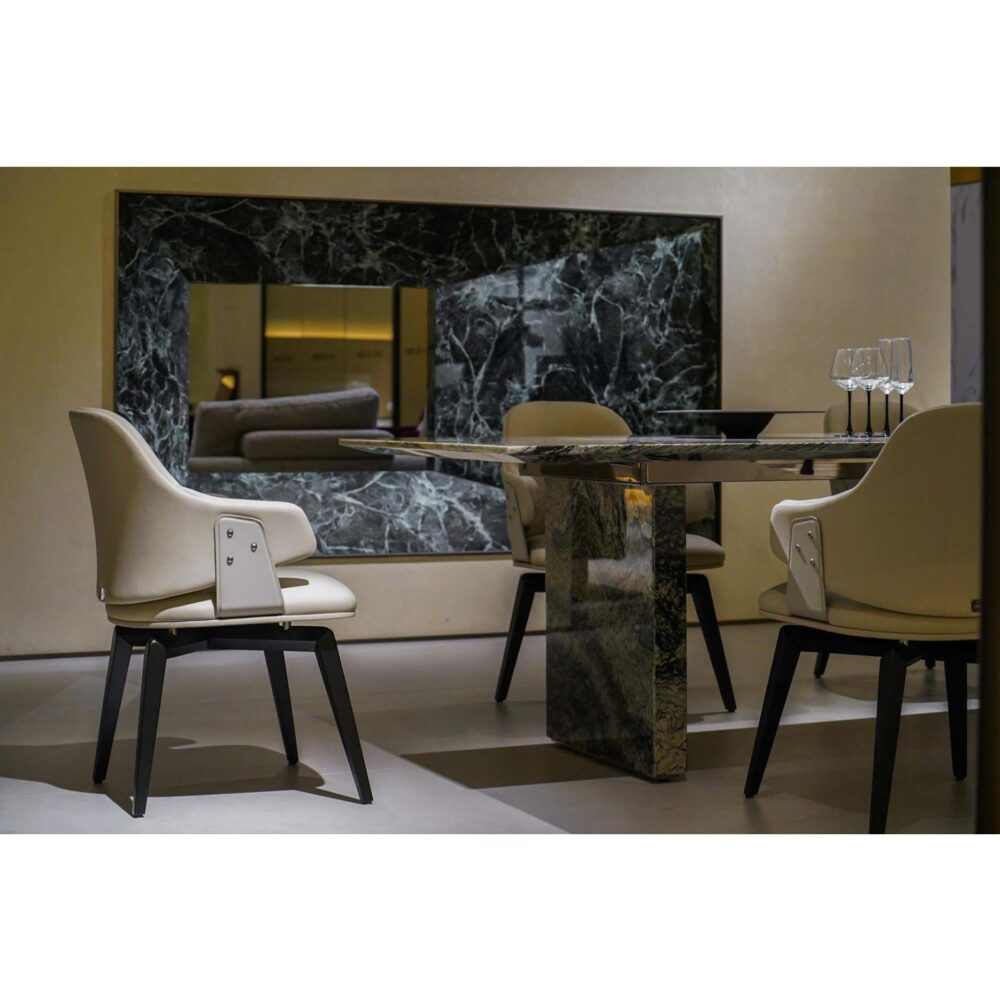 High-end modern dining setup featuring ivory leather chairs in a designer showroom