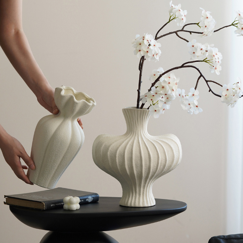 Hand arranging modern ceramic vase with branches, rustic aesthetic home scene